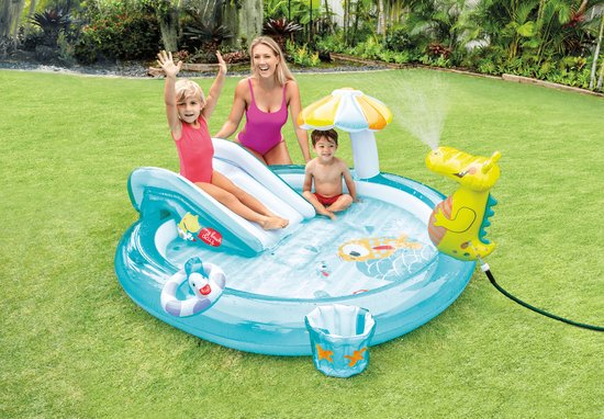Familie geniet van opblaasbaar zwembad met glijbaan, krokodil sproeier en parasol in de tuin.