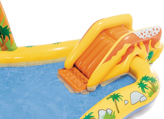 Detail van gele opblaasbare glijbaan met vulkaanprint in dinosaurus zwembad.