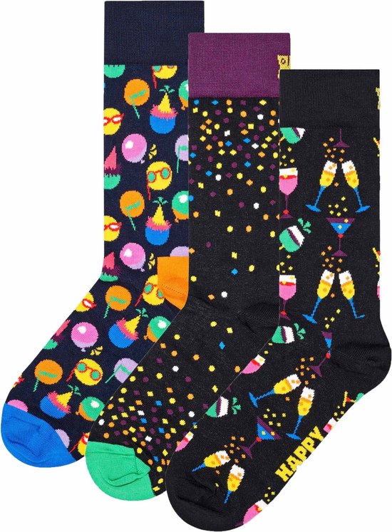Drie paar Happy Socks: één met feestelijke ballonnen en zonnebril-emoji, één met confetti en champagneglazen, en één met confetti.