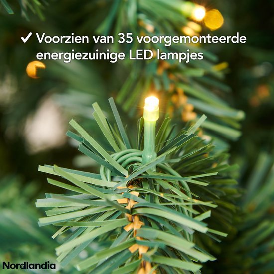 Close-up van een groene kerstslinger met een gloeiende witte LED-lampje.