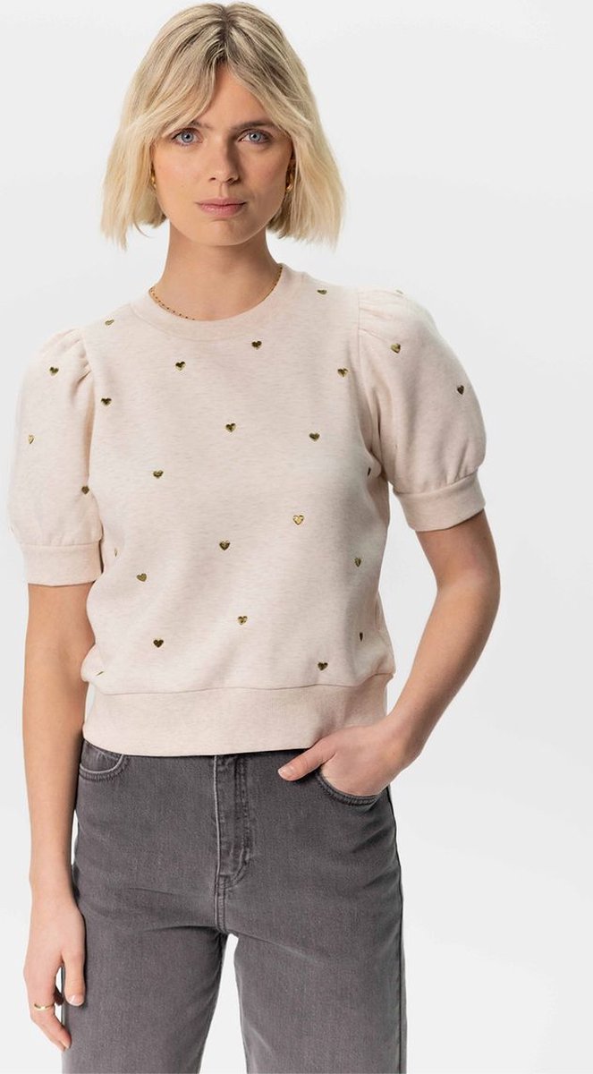 Beige sweater met korte pofmouwen en groene geborduurde hartjes. Deze sweater heeft een ronde halslijn en ribboorden langs de onderkant, de hals en aan de mouwen. Een echte musthave voor het tussenseizoen! Materiaal: 70% katoen, 30% polyester. Het model op de foto is 1,79 m en draagt maat S. - 0