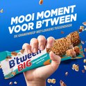 Hand die een B'tween BIG Gezouten Karamel reep vasthoudt. De reep bevat granen, karamel en chocolade.