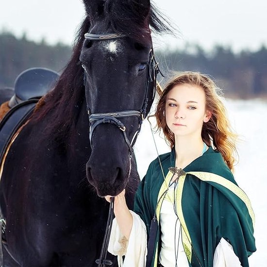 Model met een groene cape vastgezet met een antieke broche.