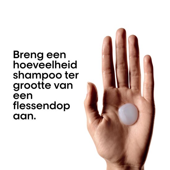 Hand met een druppel lichte, parelmoerachtige shampoo in de palm. Tekst in het Nederlands: 'Breng een hoeveelheid shampoo ter grootte van een flessendop aan.'
