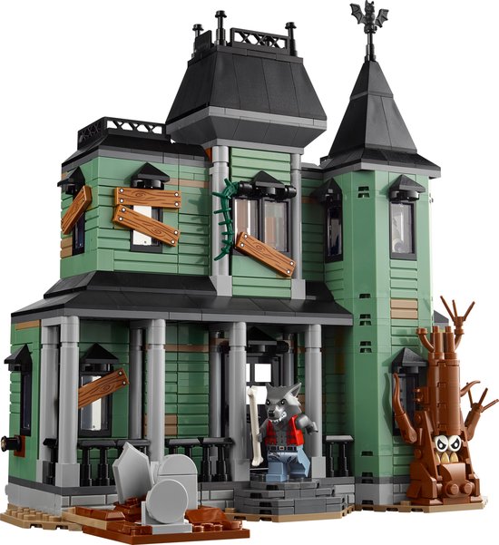 Une maison hantée verte avec un loup-garou et une pierre tombale.