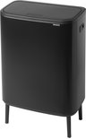 Poubelle Brabantia noire à deux compartiments, posée sur quatre pieds noirs. Le couvercle est fermé.