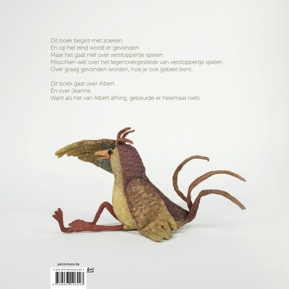 Een gekleurde stoffen vogel, liggend op zijn zij met gespreide poten en staartveren. Er staat tekst van het boek.