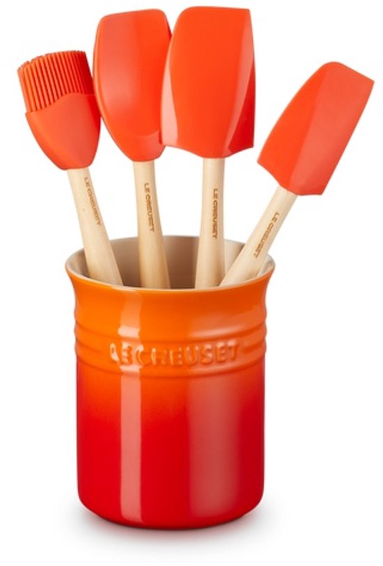 Le Creuset aardewerken oranjerode pot met vier oranje siliconen spatels, waaronder een kwast.