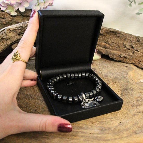 Hematiet armband met facet geslepen kraaltjes en een zilverkleurige cirkelbedel met zirkonia.