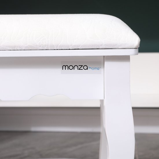 Close-up van het zitvlak en de zijkant van een witte kaptafelkruk met Monza Home logo.