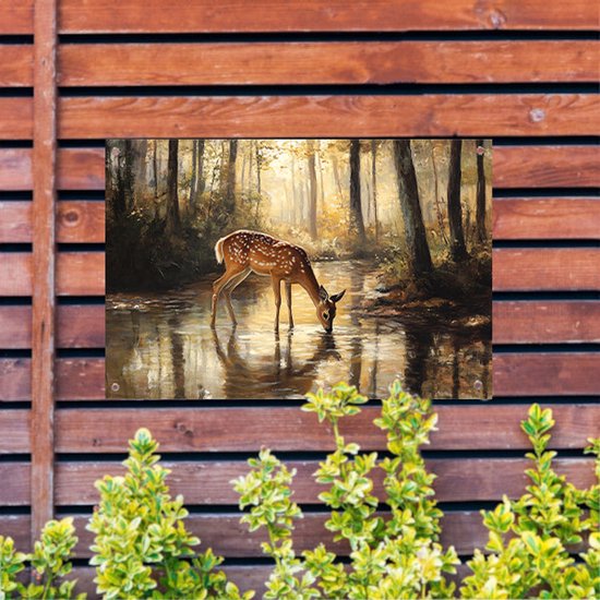 Een tuinposter met een schilderij van een hert dat uit een bosvijver drinkt, hangt aan een houten schutting.