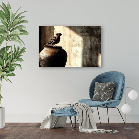 Een bruine vogel op een pot, hangend aan een muur boven een blauwe fauteuil in een woonkamer.
