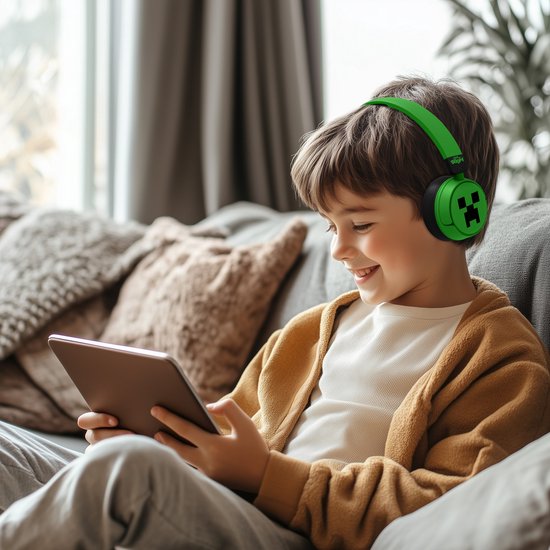 Jongen met groene Minecraft koptelefoon op tablet kijkend