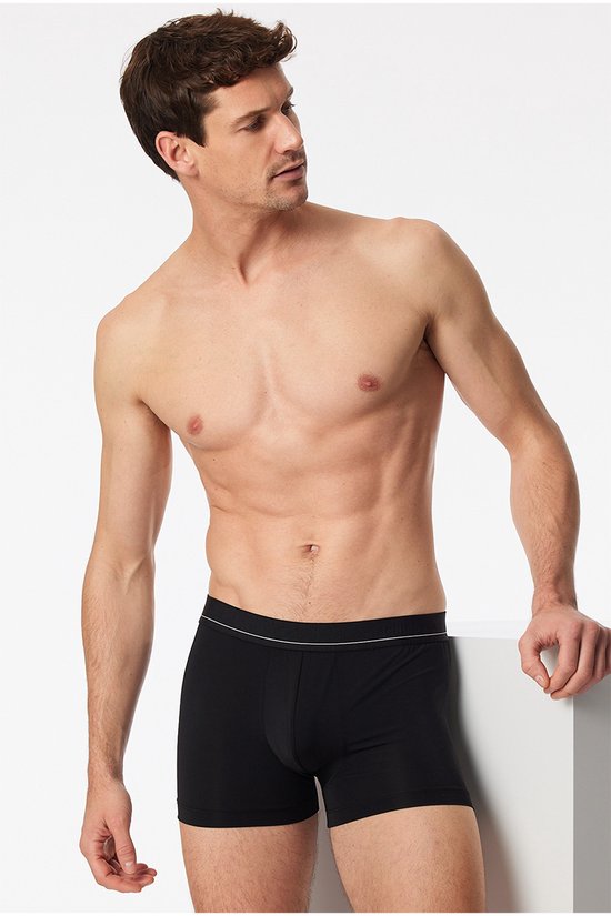 Model op een man, zwarte short met elastische band met witte streepjes.