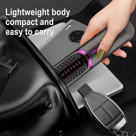 Compacte grijze haarstyler in een handtas, naast een telefoon en sleutels.