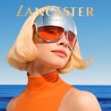 Model met blond haar en oranje coltrui, draagt futuristische zonnebril met spiegelende glazen.