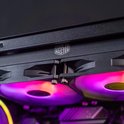 Close-up van de bovenkant van een computerkast met Cooler Master logo en verlichte ventilatoren.