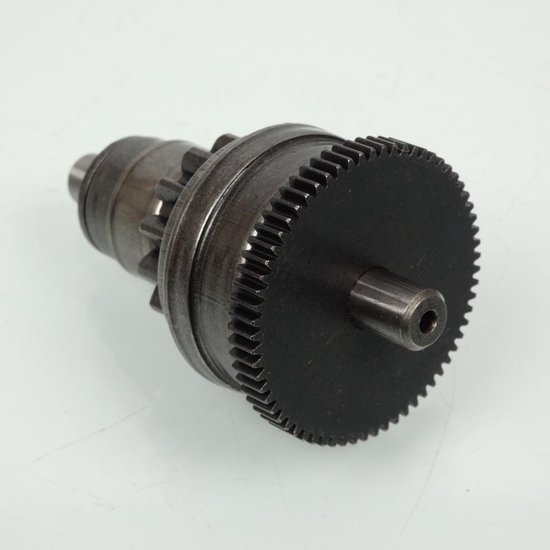 Bendix d'embrayage de démarreur argenté avec engrenages et une grande roue dentée noire sur la droite.