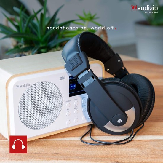 DAB radio met wit front en houten kast, met een zwarte koptelefoon erop.