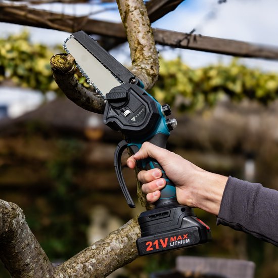 Hand met teal mini kettingzaag die een tak doorsnijdt, met blauwe details en 21V batterij.