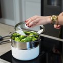 Stoompan met broccoli, glazen deksel en witte handgrepen.