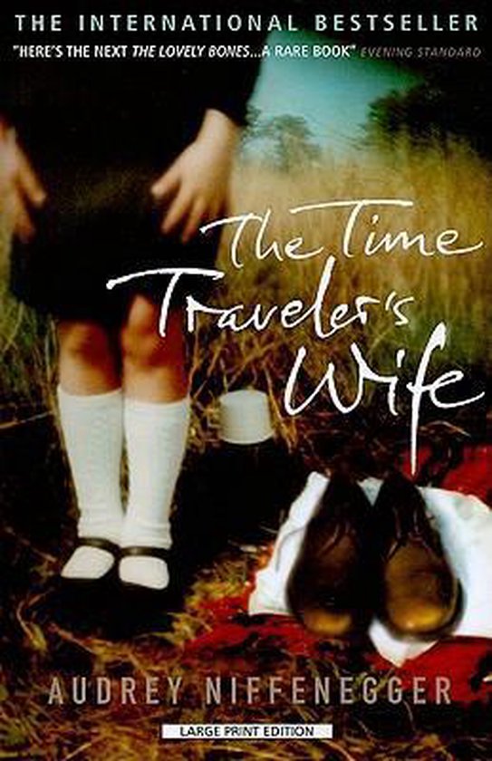 Boekcover van 'The Time Traveler's Wife' van Audrey Niffenegger. Een kind met witte kousen staat in gras, met een boek en schoenen op de grond.