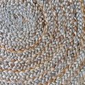 Detail van het spiraalvormige vlechtwerk van een rond jute vloerkleed.