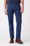 Blauwe Wrangler jeans, regular fit, gedragen met donkerblauwe T-shirt en rode schoenen.