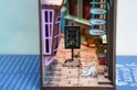 Twee miniatuurkatten op de straat van een boekensteun met een café-gevel.