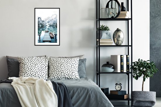 Winterlandschap met bergen, water en boten, in zwarte lijst, boven bed.