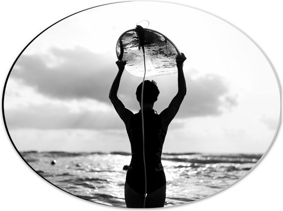 Dibond Ovaal - Achteraanzicht van Persoon met Surfplank boven het Hoofd (Zwart-wit) - 40x30 cm Foto op Ovaal (Met Ophangsysteem)