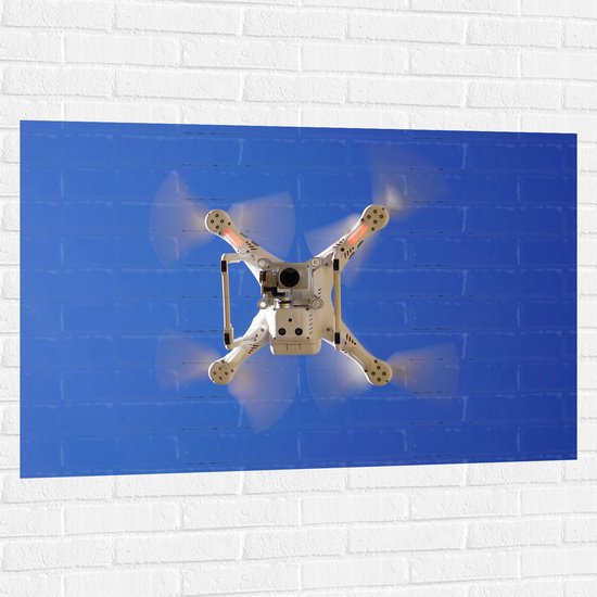 Muursticker - Onderaanzicht van Vliegende Drone onder Blauwe Lucht - 120x80 cm Foto op Muursticker