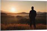 Vlag - Silhouet van Man kijkend naar Zonsondergang in Landschap - 90x60 cm Foto op Polyester Vlag