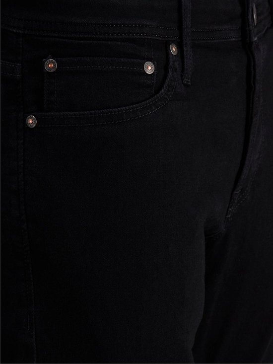 Detail van de zakken van een zwarte jeans met klinknagels.