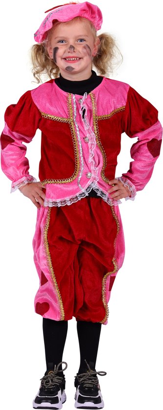 Meisje in roze en rood Pietenkostuum met hartjes, kappen met veren, gezichtssmink en zwarte schoenen, handen in de zij.