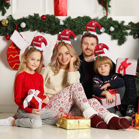 Een gezin met kerstmutsen met 'HO HO HO' en sneeuwvlokken, zittend bij een kerstboom met cadeautjes.