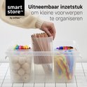 Transparante opbergdoos met vakverdelers, gevuld met potloden, bollen, pijpenreinigers en stiften.