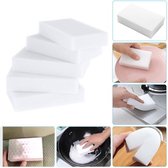 Stapel witte melamine sponzen, sommige worden gebruikt op een bord en fornuis.