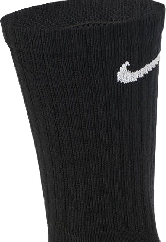 Een detailopname van de bovenkant van een zwarte sportsok met een wit Nike 'swoosh' logo.