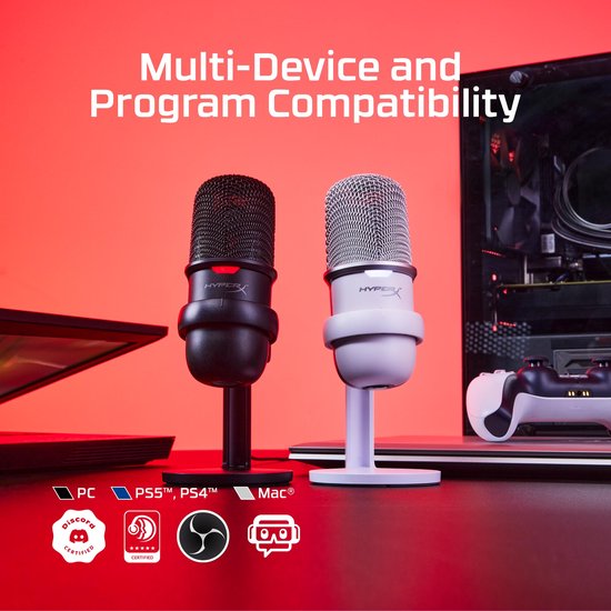 Zwarte en witte HyperX microfoons met standaard, naast een laptop en gameconsole.
