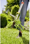 GARDENA onkruidsteker verwijdert paardenbloem met wortel uit gras, vrouw in jeans.