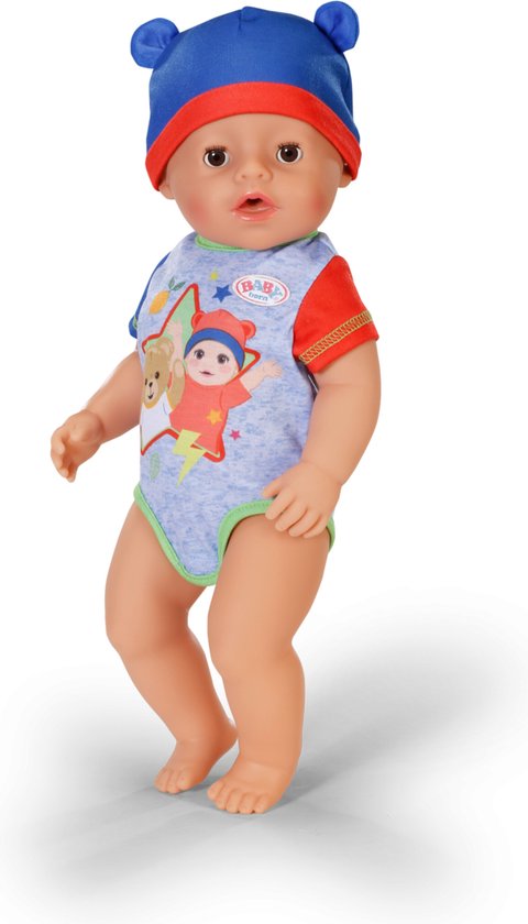 Jongen met blauwe muts en romper met beerprint. Staand op witte achtergrond.