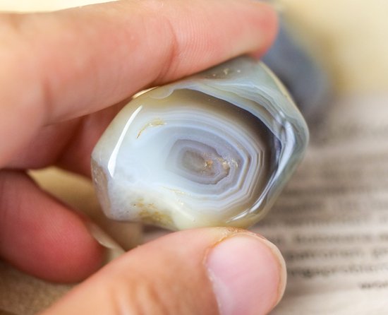 Gladde, gepolijste Botswana agaat trommelsteen met concentrische witte en bruine lagen.