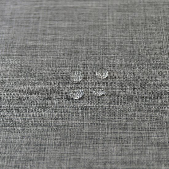 Druppels water op antracietkleurig linnen.
