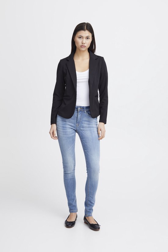 Model draagt een zwarte Ichi blazer met jeans en een witte top.