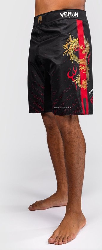 Zijaanzicht van zwarte fightshorts met gouden draak, rode streep en rode spetters.