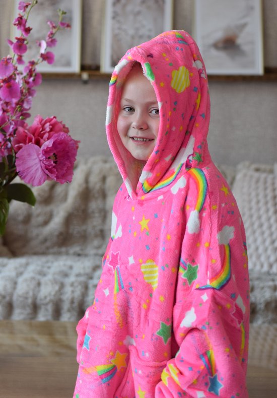 Meisje in neonroze hoodie deken met eenhoorns, regenboog en sterrenprint.