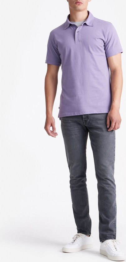 Man in lavendelkleurig poloshirt met korte mouwen en grijze jeans, staand.