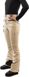 Vrouw in beige skibroek met zwarte accenten, zwarte schoenen en een zwarte top.