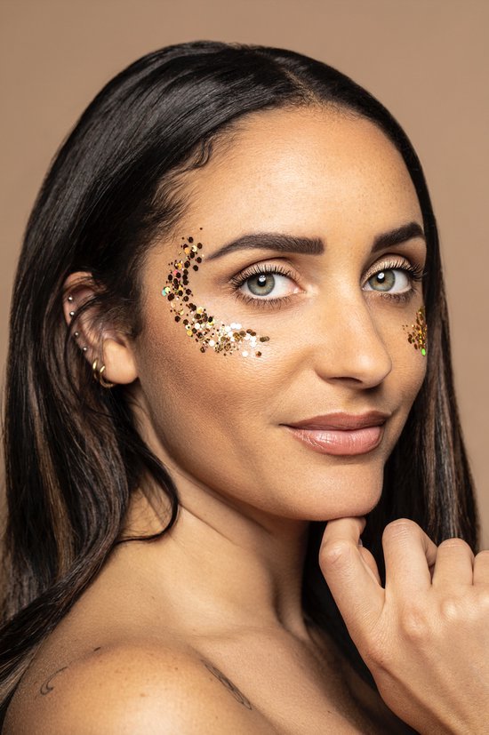 Model met gouden glitters op haar gezicht.